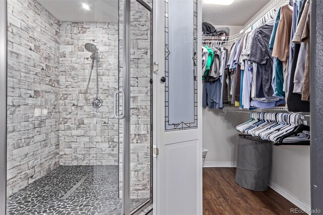 105 Hawthorn St, Frederick, CO 80530 - bathroom with a shower stall, wood finished floors, a walk in closet, and baseboards