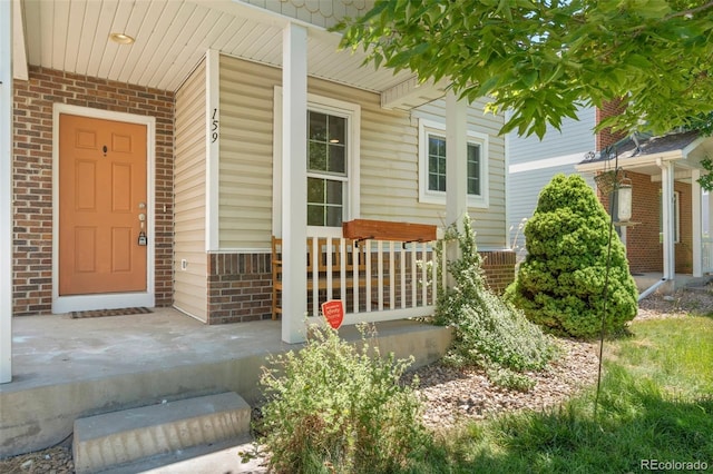 view of exterior entry featuring covered porch