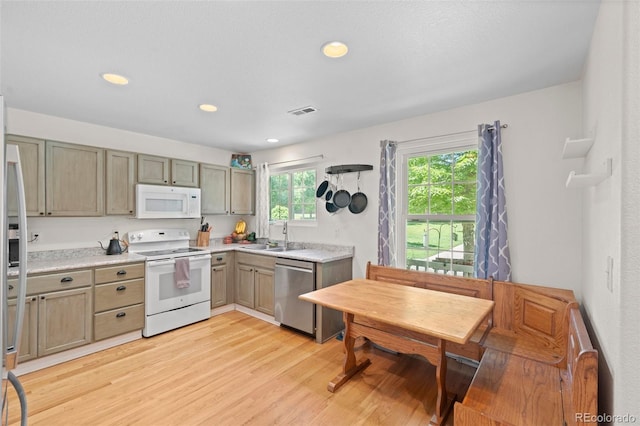 kitchen with radiator, light hardwood / wood-style flooring, white appliances, and sink