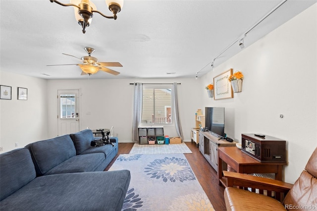 living room with a textured ceiling, dark hardwood / wood-style floors, and rail lighting