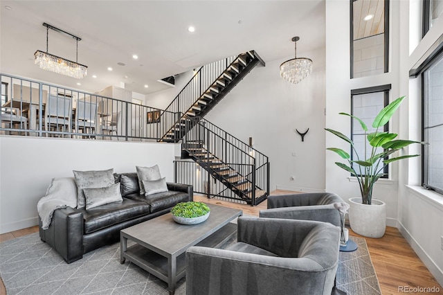 living area featuring recessed lighting, stairway, wood finished floors, a chandelier, and baseboards