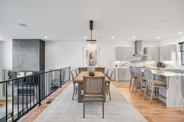 dining room with light wood-style floors, recessed lighting, and an inviting chandelier