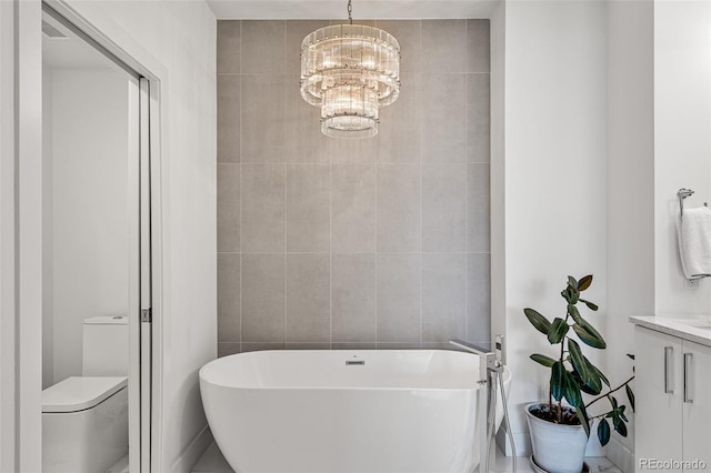 full bathroom with a chandelier, a soaking tub, tile walls, and toilet