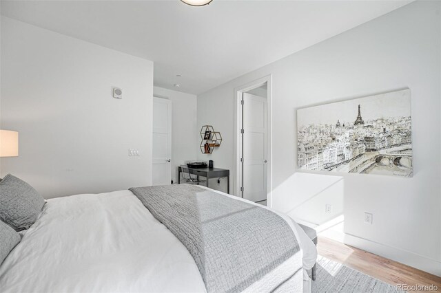 bedroom featuring baseboards and light wood finished floors