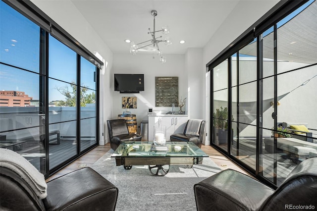 living area featuring recessed lighting, a notable chandelier, and wood finished floors