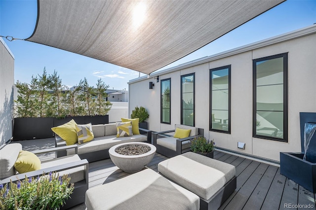 wooden terrace with an outdoor living space with a fire pit and fence