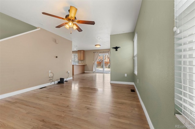 unfurnished living room featuring ceiling fan and light hardwood / wood-style flooring