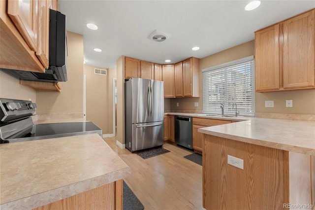 kitchen featuring light brown cabinets, sink, stainless steel appliances, and light hardwood / wood-style flooring