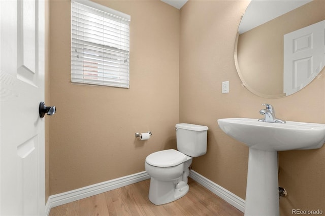 bathroom featuring hardwood / wood-style flooring, toilet, and sink