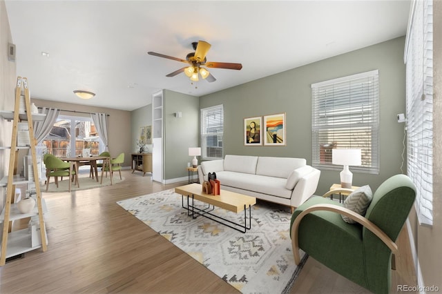 living room featuring ceiling fan and light hardwood / wood-style floors