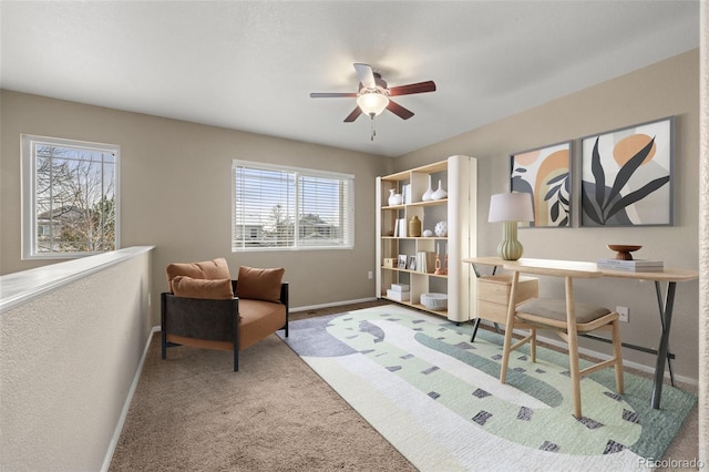 carpeted home office with ceiling fan and a healthy amount of sunlight