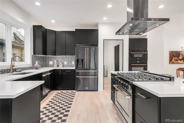 kitchen with sink, tasteful backsplash, island range hood, black appliances, and a kitchen island