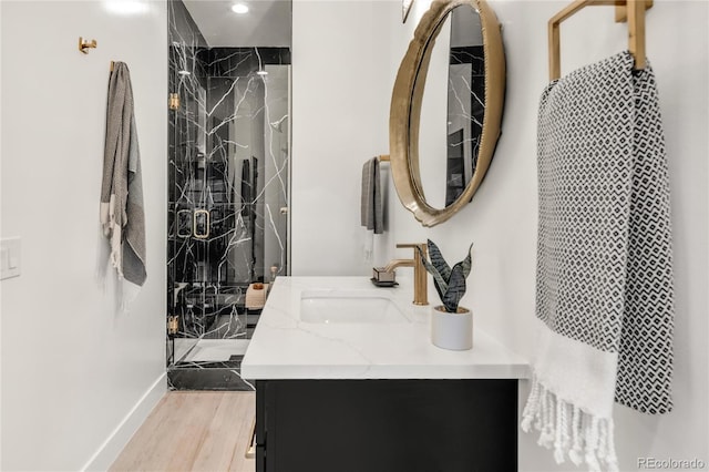 bathroom featuring a shower with door, vanity, and wood-type flooring