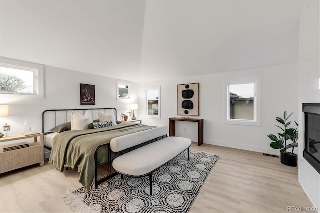 bedroom with a high ceiling and light wood-type flooring