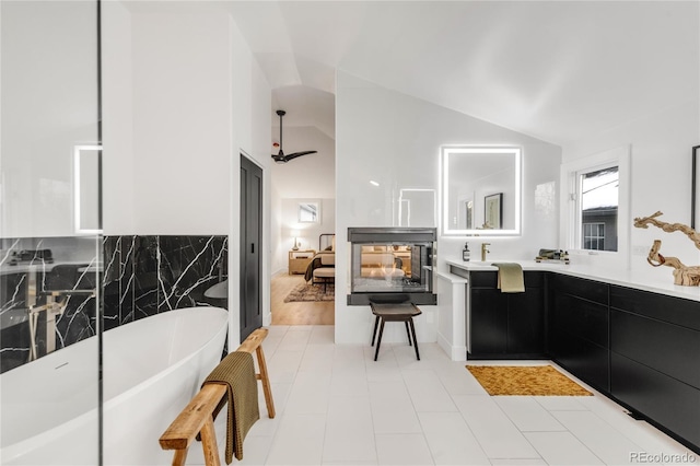 bathroom with lofted ceiling, a bathing tub, and vanity