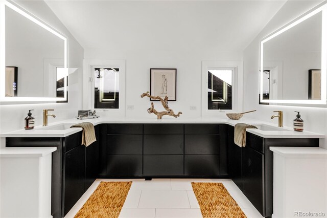 bathroom featuring vanity, tile patterned flooring, and vaulted ceiling