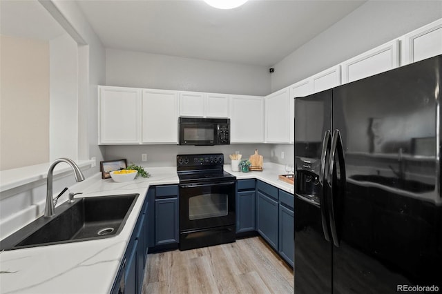 kitchen with blue cabinetry, white cabinetry, sink, light hardwood / wood-style floors, and black appliances