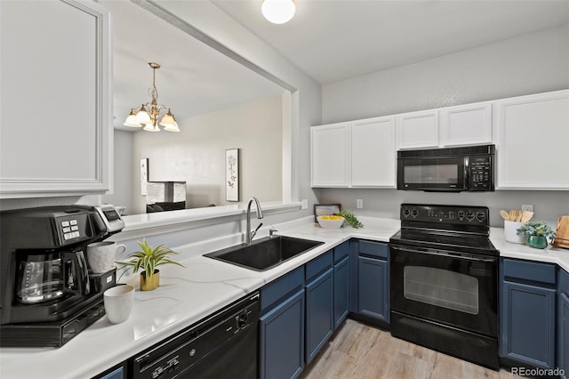 kitchen with blue cabinetry, a chandelier, sink, and black appliances