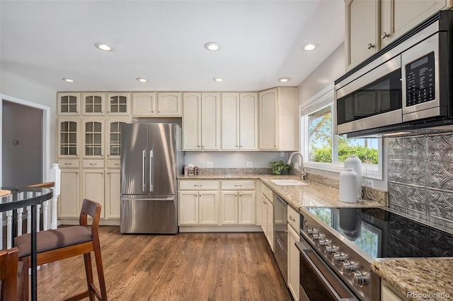 6150 S Southwood Dr, Centennial, CO 80121 - kitchen with appliances with stainless steel finishes, a sink, cream cabinets, recessed lighting, and light stone counters