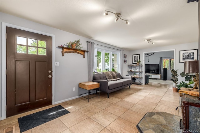 tiled entryway featuring track lighting