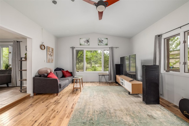 living room with ceiling fan, lofted ceiling, plenty of natural light, and light hardwood / wood-style flooring