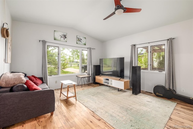 living room featuring ceiling fan, light wood-type flooring, vaulted ceiling, and a wealth of natural light