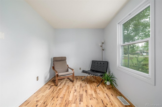 sitting room with a healthy amount of sunlight and light hardwood / wood-style flooring