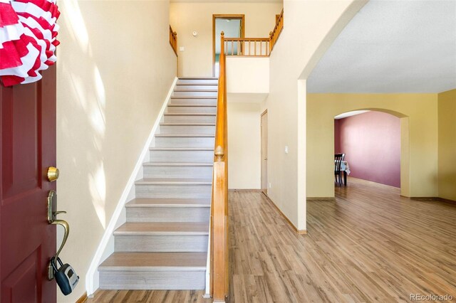 19817 E Prentice Ave, Centennial, CO 80015 - entrance foyer featuring arched walkways, wood finished floors, stairway, a towering ceiling, and baseboards
