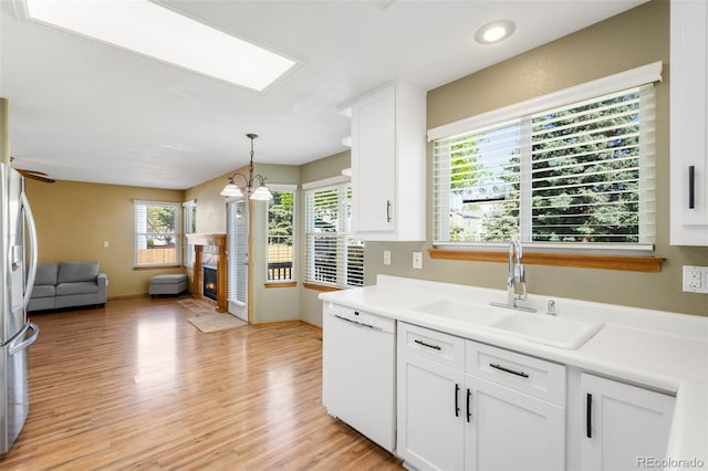 19817 E Prentice Ave, Centennial, CO 80015 - kitchen with white dishwasher, a sink, open floor plan, white cabinets, and light wood finished floors