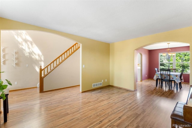 19817 E Prentice Ave, Centennial, CO 80015 - living area with arched walkways, a chandelier, light wood-type flooring, baseboards, and stairway