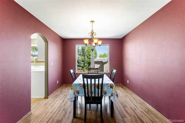 19817 E Prentice Ave, Centennial, CO 80015 - dining space with plenty of natural light, wood finished floors, a textured wall, arched walkways, and a chandelier