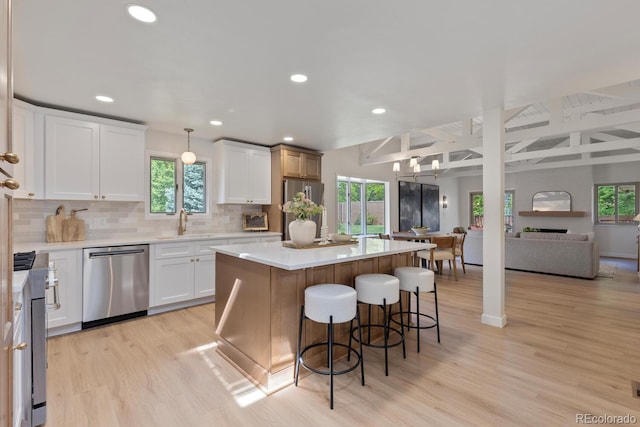 41 Eagle Dr, Littleton, CO 80123 - kitchen with appliances with stainless steel finishes, light wood-style flooring, recessed lighting, open floor plan, and tasteful backsplash