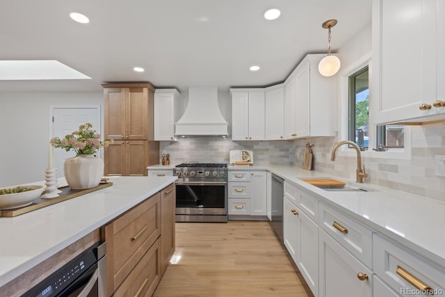 41 Eagle Dr, Littleton, CO 80123 - kitchen featuring stainless steel appliances, premium range hood, a sink, light countertops, and light wood-type flooring