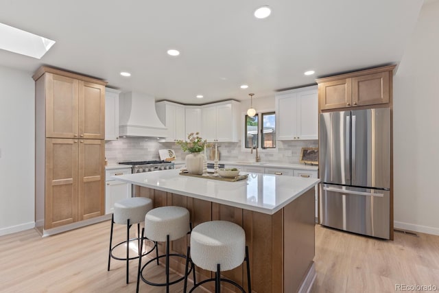 41 Eagle Dr, Littleton, CO 80123 - kitchen featuring freestanding refrigerator, custom range hood, baseboards, light wood-style flooring, and recessed lighting