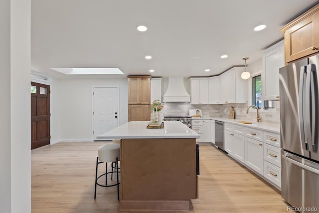 41 Eagle Dr, Littleton, CO 80123 - kitchen featuring appliances with stainless steel finishes, custom range hood, a sink, a kitchen island, and decorative backsplash