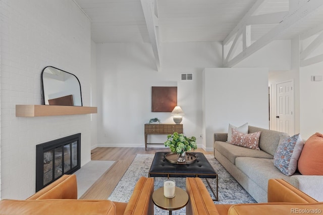 41 Eagle Dr, Littleton, CO 80123 - living room with wood finished floors, beamed ceiling, a large fireplace, baseboards, and high vaulted ceiling
