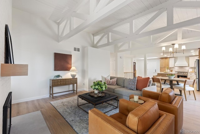 41 Eagle Dr, Littleton, CO 80123 - living area featuring high vaulted ceiling, light wood-type flooring, baseboards, beam ceiling, and a chandelier