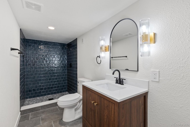 41 Eagle Dr, Littleton, CO 80123 - full bath featuring a tile shower, toilet, tile patterned floors, vanity, and a textured wall