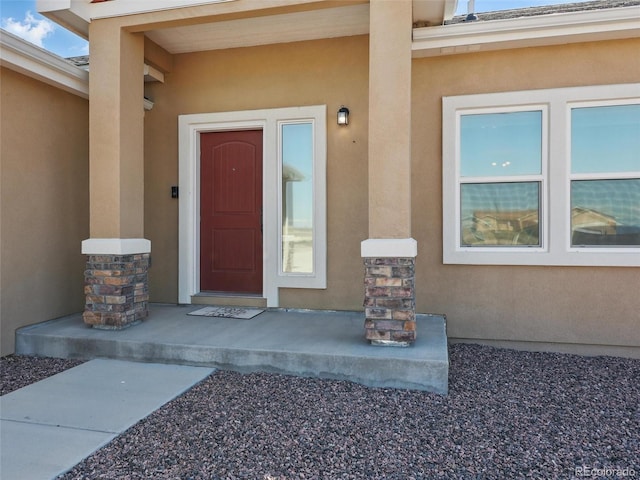 entrance to property featuring stucco siding
