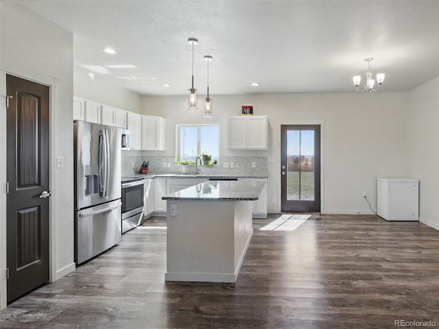 kitchen featuring appliances with stainless steel finishes, a kitchen island, tasteful backsplash, white cabinetry, and recessed lighting