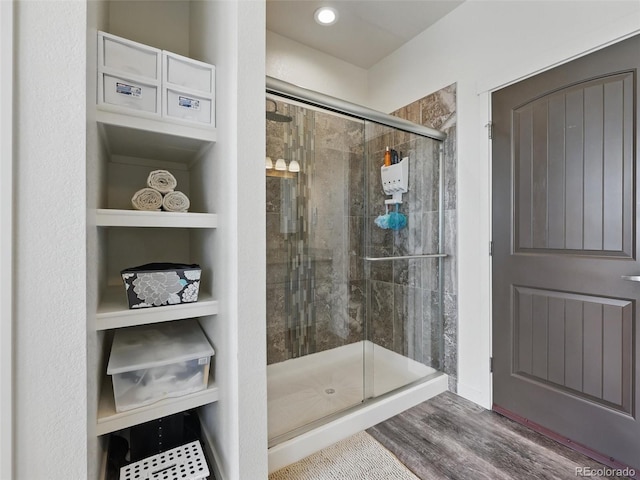 bathroom with a stall shower and wood finished floors