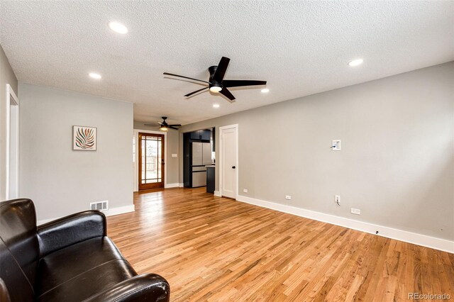 1945 Yosemite St, Denver, CO 80220 - living room with light wood-type flooring, a ceiling fan, a textured ceiling, baseboards, and recessed lighting