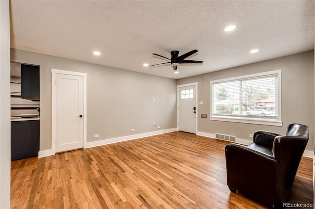 1945 Yosemite St, Denver, CO 80220 - living room with a ceiling fan, light wood finished floors, a textured ceiling, recessed lighting, and baseboards