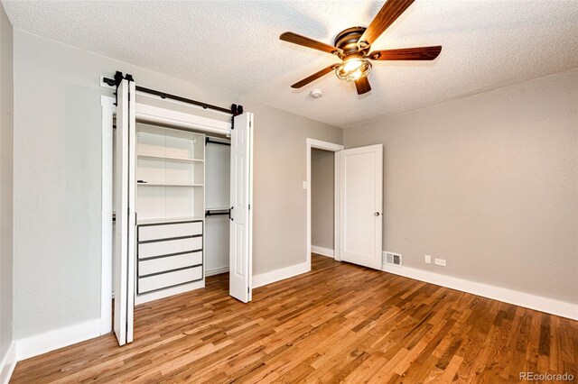 1945 Yosemite St, Denver, CO 80220 - unfurnished bedroom featuring light wood-type flooring, baseboards, a textured ceiling, and a closet