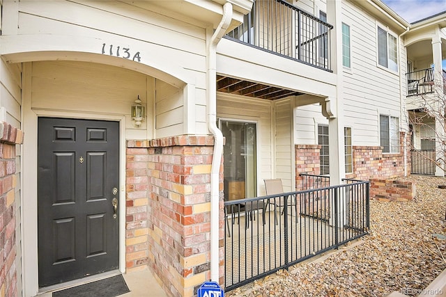 view of exterior entry with a balcony