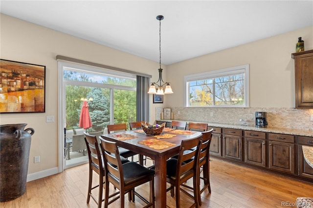 15003 W 63rd Ave, Arvada, CO 80403 - dining space with light wood-style floors, plenty of natural light, and a chandelier