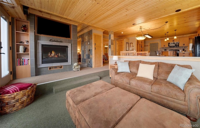 carpeted living room featuring a tiled fireplace and wooden ceiling