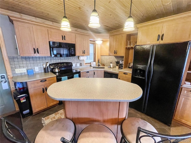 kitchen featuring light brown cabinetry, black appliances, a center island, and hanging light fixtures