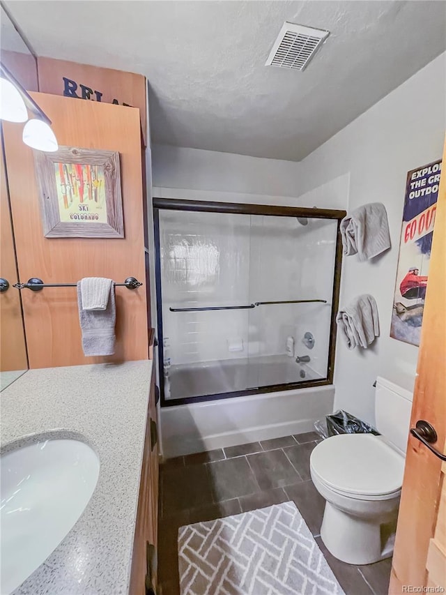 full bathroom with vanity, toilet, and shower / bath combination with glass door