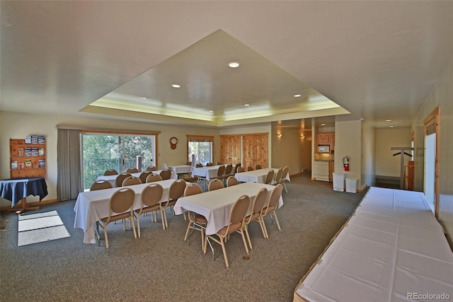 dining area featuring carpet and a raised ceiling